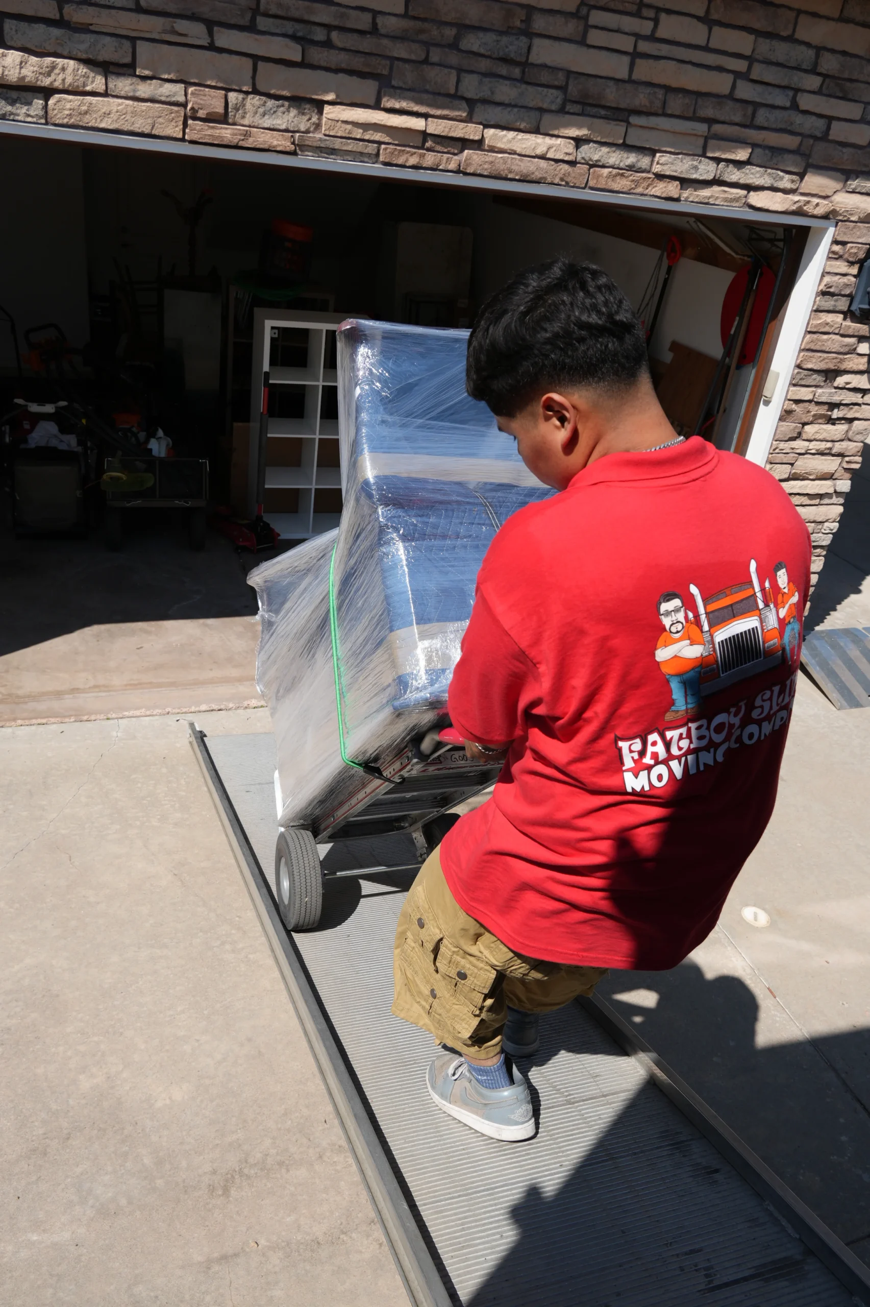 Fatboy Slims mover transporting wrapped furniture from a Colorado home.