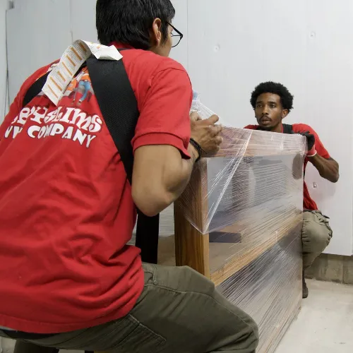 Fatboy Slims Moving Company movers carefully handling wrapped furniture.