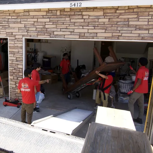 Fatboy Slims Moving Company crew moving furniture and household items from a garage.