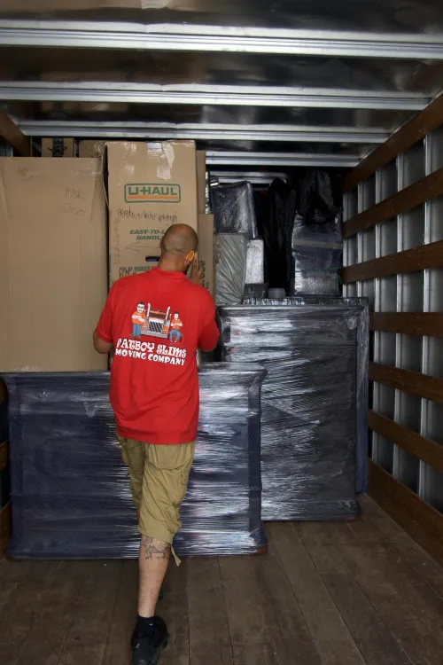 Fatboy Slims mover arranging wrapped furniture and boxes inside a moving truck in Colorado.