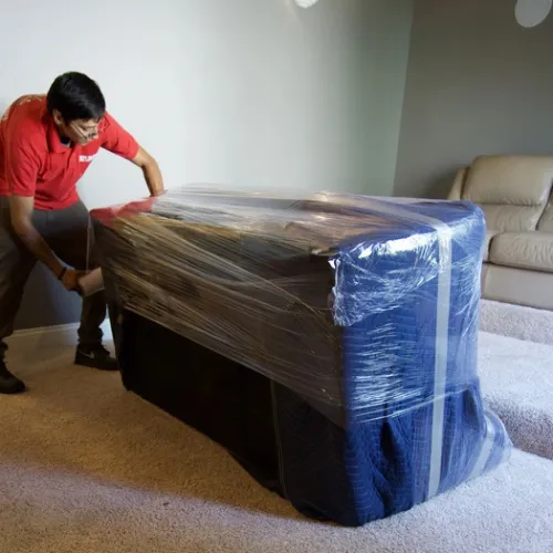 Fatboy Slims mover wrapping furniture for protection during a move.