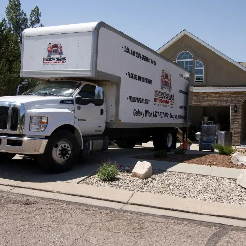 Fatboy Slims Moving Company truck parked outside a home.