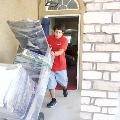 Fatboy Slims Moving Company mover carefully transporting wrapped furniture from a home in Colorado Springs.