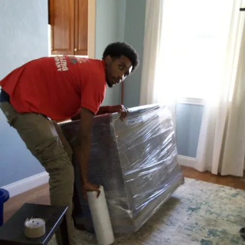 Fatboy Slims Moving Company mover wrapping furniture for protection.