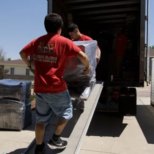 Fatboy Slims Moving Company movers loading wrapped furniture into a moving truck.