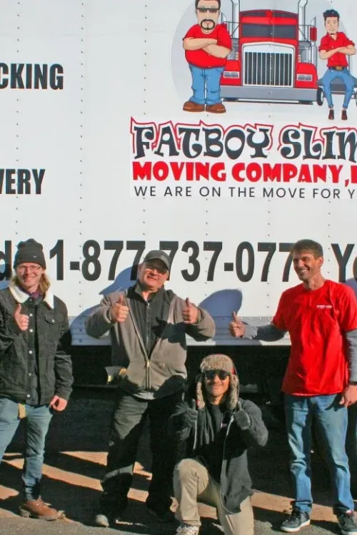 oy Slims Moving Company crew posing in front of a branded moving truck.